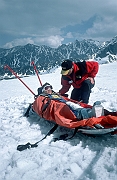 Zwozka narciarska. Poszkodowana narciarka w akii, czeka na transport. Przy poszkodowanej ratownik TOPR - Adam Marasek.
